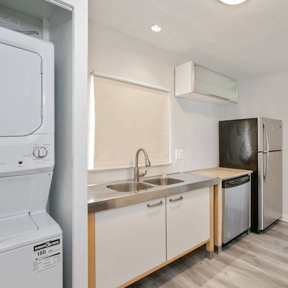 a kitchen with white cabinets and stainless steel appliances and a refrigerator