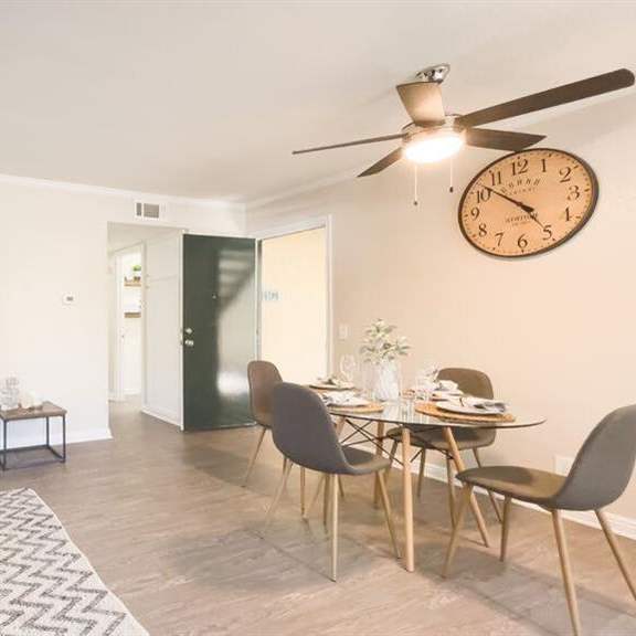 a living room with a couch a table and a clock