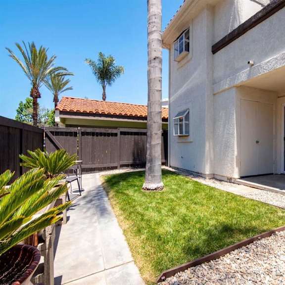 a white house with a palm tree in the front yard