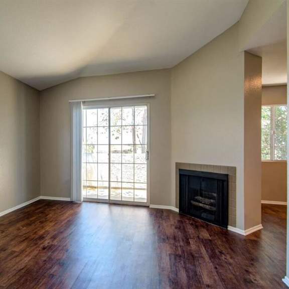 an empty living room with a fireplace and a large window