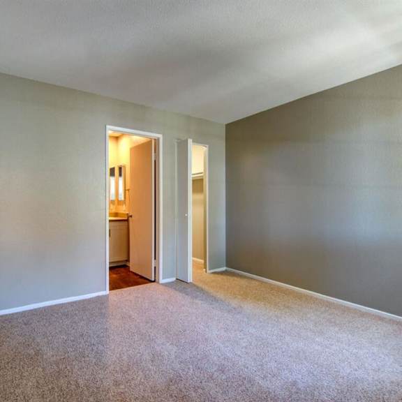 a large empty room with a doorway to a bathroom
