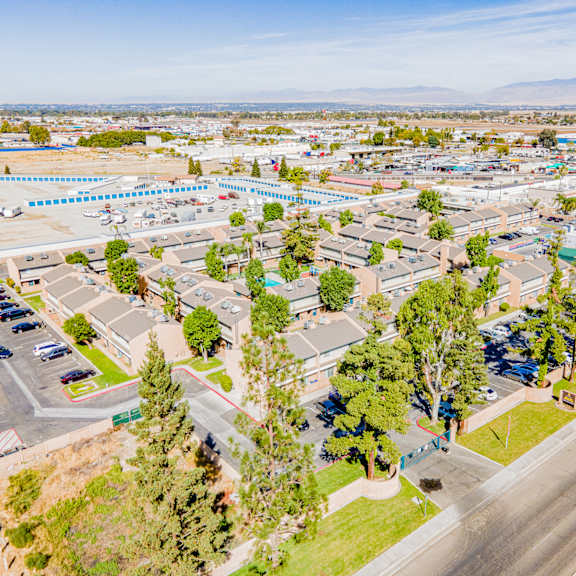 an aerial view of a parking lot with cars and trees