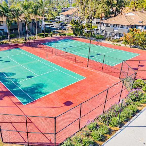 a tennis court surrounded by a fence and trees at metro 3610, riverside, 92505