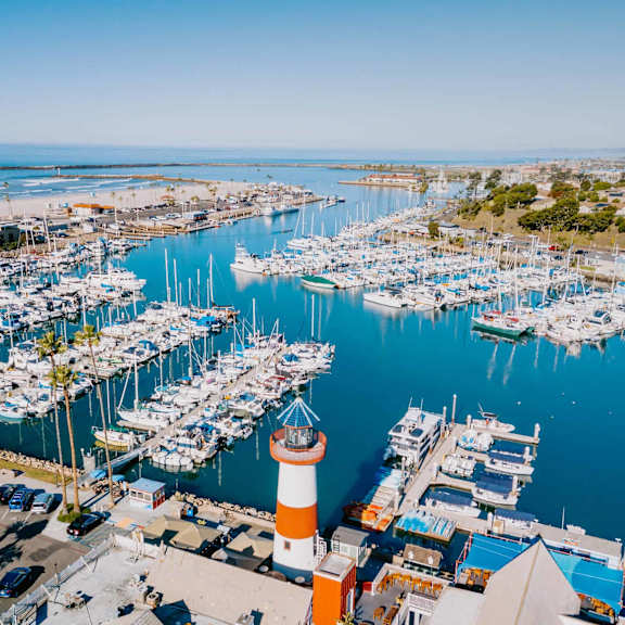 a view of the marina with many boats and a lighthouse