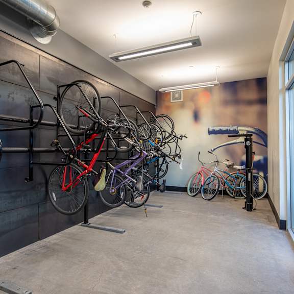 a row of bikes hanging on a wall in a room with a window