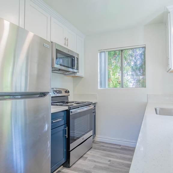 a kitchen with a stainless steel refrigerator, microwave, oven, and sink.