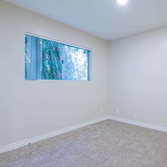 a room with a window and carpeted floor.