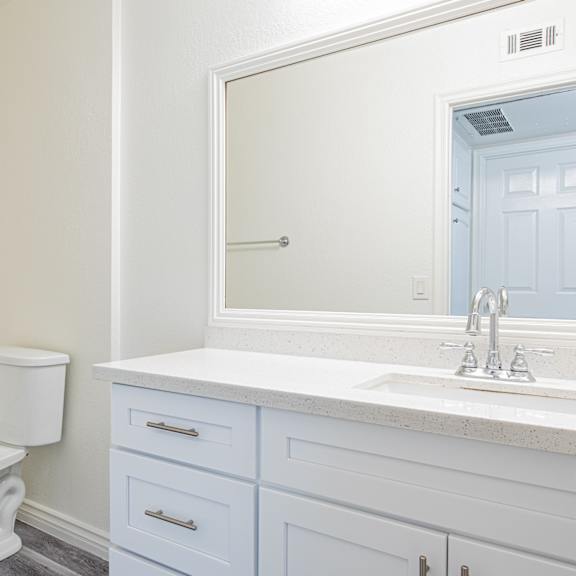 a white toilet sits next to a sink in a bathroom.