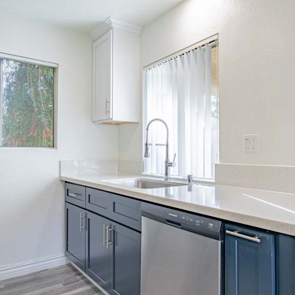 a kitchen with a white counter top and blue cabinets.