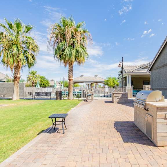 the backyard has a grill and a picnic table and palm trees at villas on olive, peoria, arizona