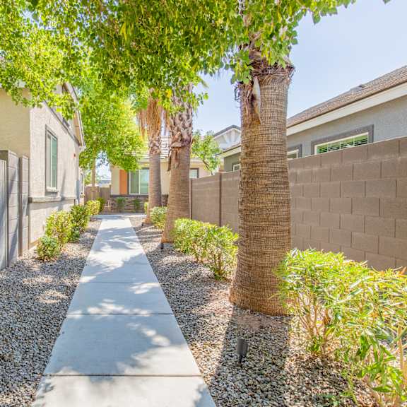 a long walkway with trees in front of a house at villas on olive, peoria, arizona
