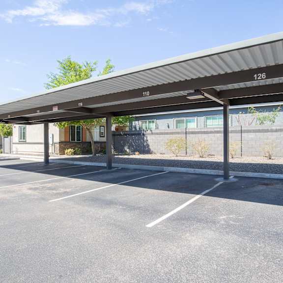 an empty parking lot with a canopy in front of a building at villas on olive, peoria, arizona