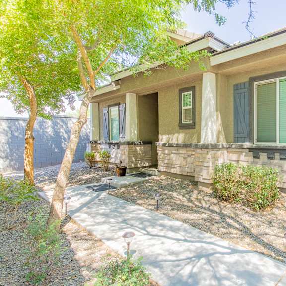 a house with green shutters and a sidewalk in front of it at villas on olive, peoria, arizona