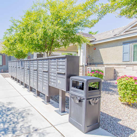 a driveway with a fence and a trash can in front of a house at villas on olive, peoria, arizona
