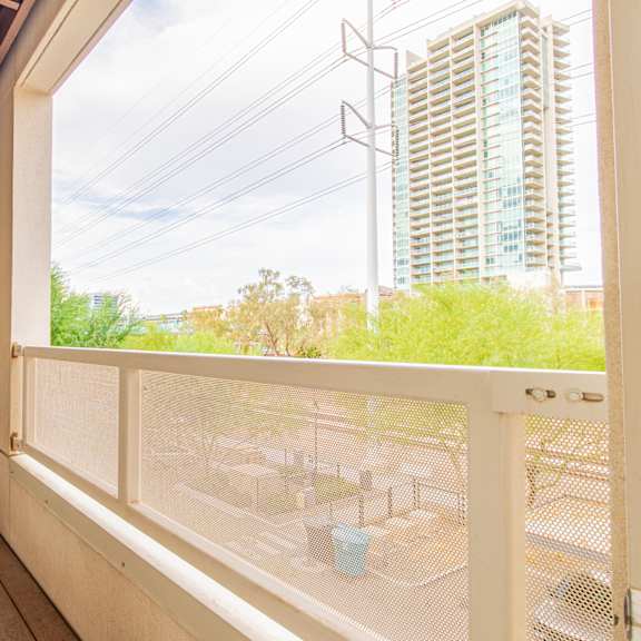 a balcony with a large window and a view of a building