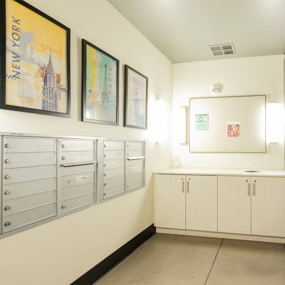 a utility room with white cabinets and drawers and pictures on the wall