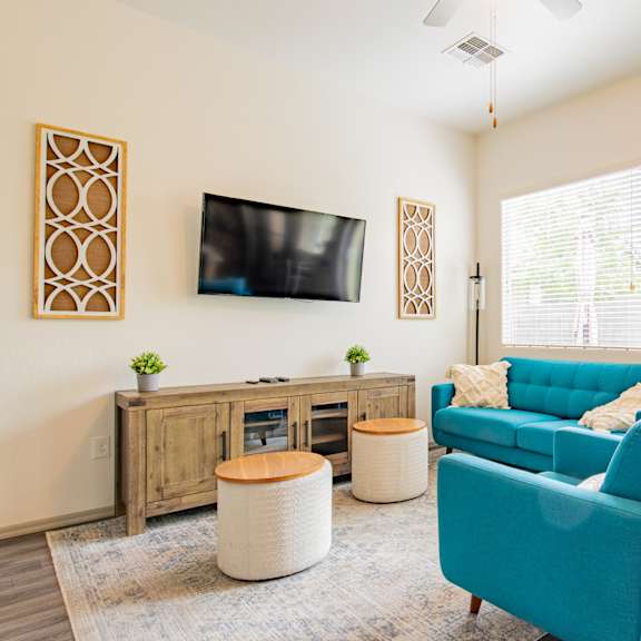 a living room with a blue couch and a tv at villas on olive, peoria, arizona