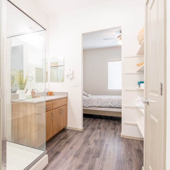 a bathroom with a shower and a sink and a bedroom at villas on olive, peoria, arizona 85345