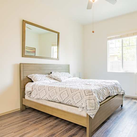 a bedroom with a bed and a dresser and a window at villas on olive, peoria, arizona