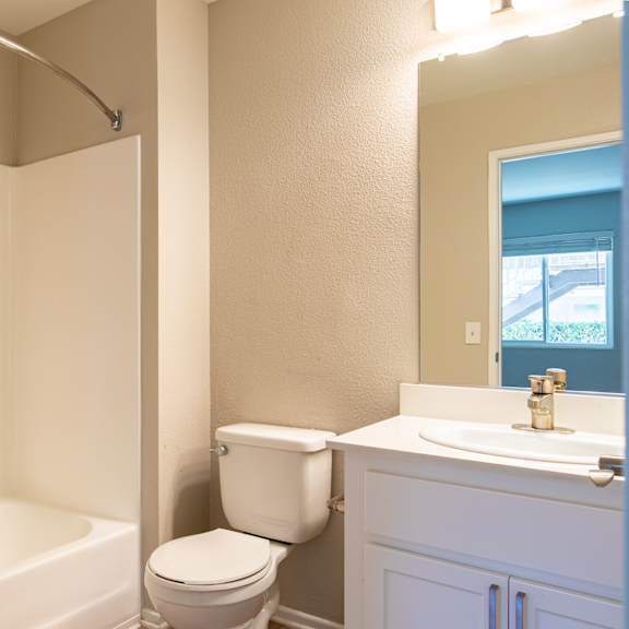 a bathroom with a toilet and a tub and a sink