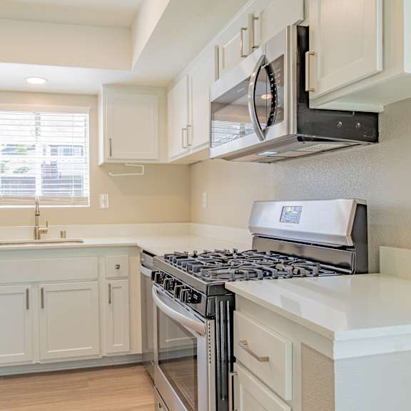 a kitchen with white cabinets and a stove and a refrigerator