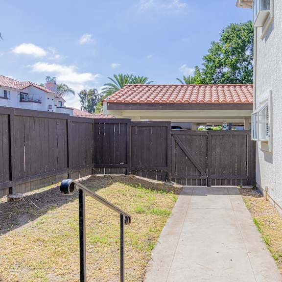 the entrance to a fenced in yard of a house