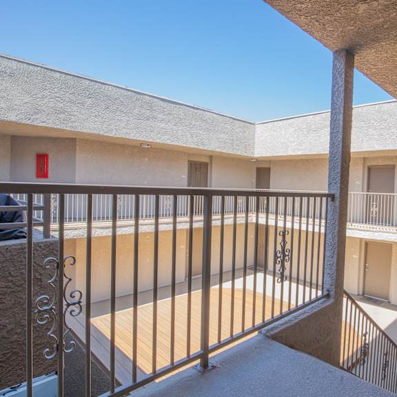 a balcony with a metal railing and a red fire extinguisher on the wall.