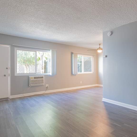 an empty living room with white walls and a window