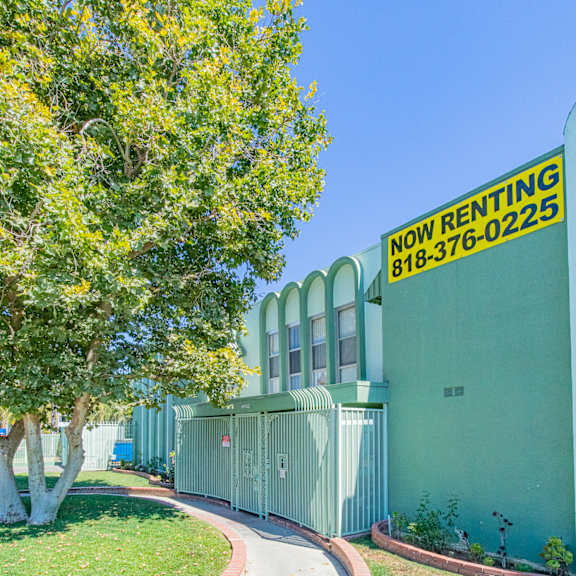 a sidewalk in front of a building with a sign for now renting