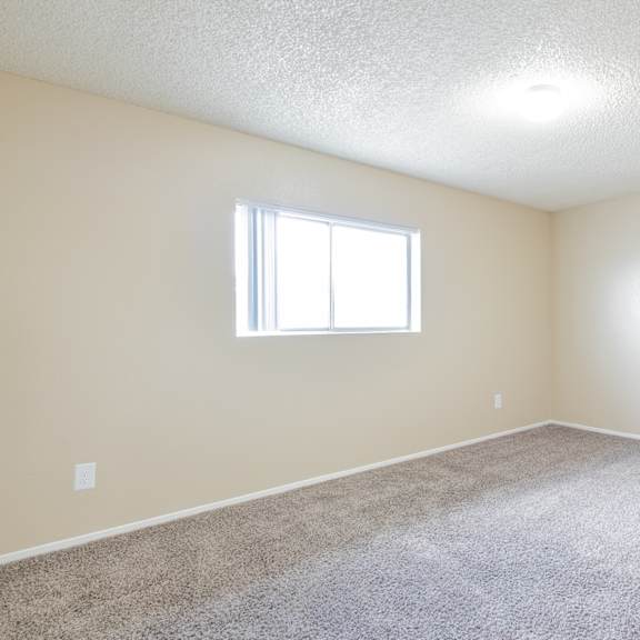 an empty room with carpet and a window