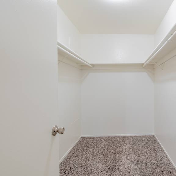 a empty room with white walls and carpet and a door