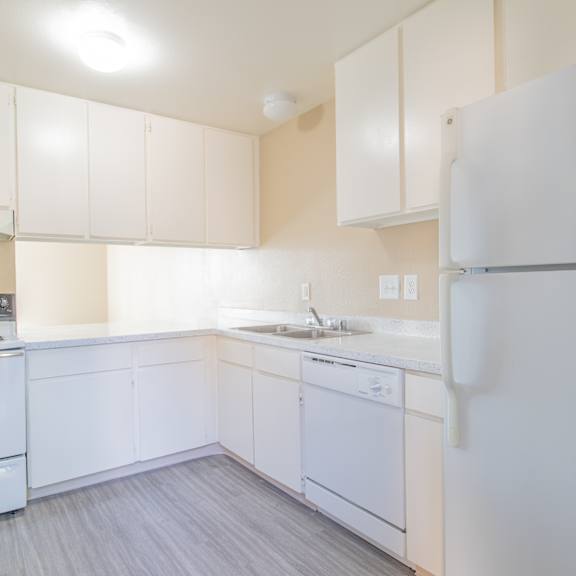 a white kitchen with white appliances and white cabinets