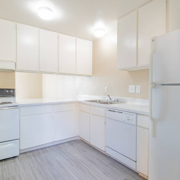 a white kitchen with white appliances and white cabinets