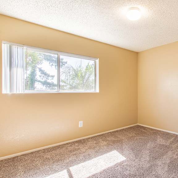an empty room with carpet and a window