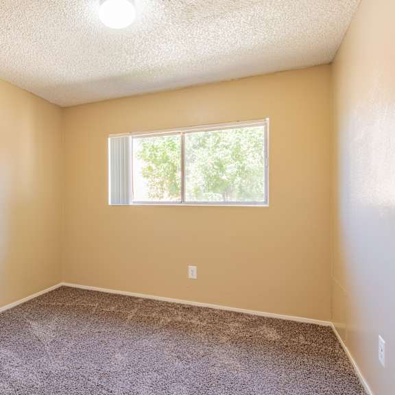 an empty room with carpet and a window