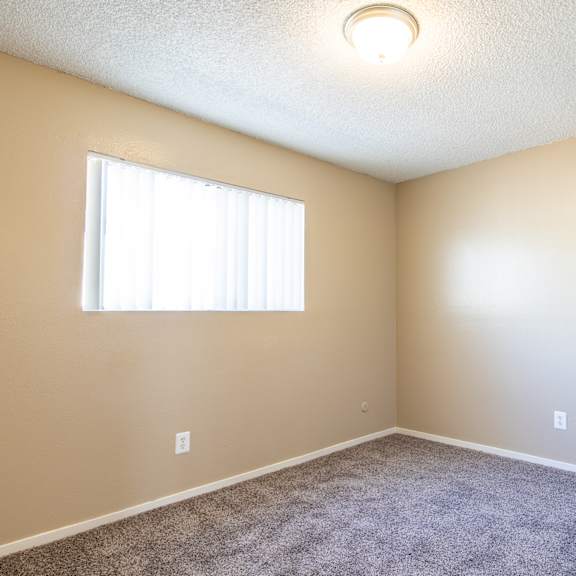 an empty room with carpet and a window