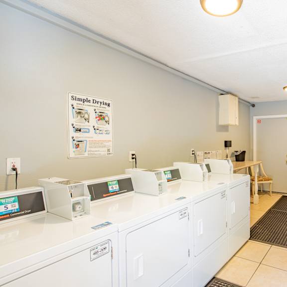 a laundry room with washers and dryers and a door to a room with
