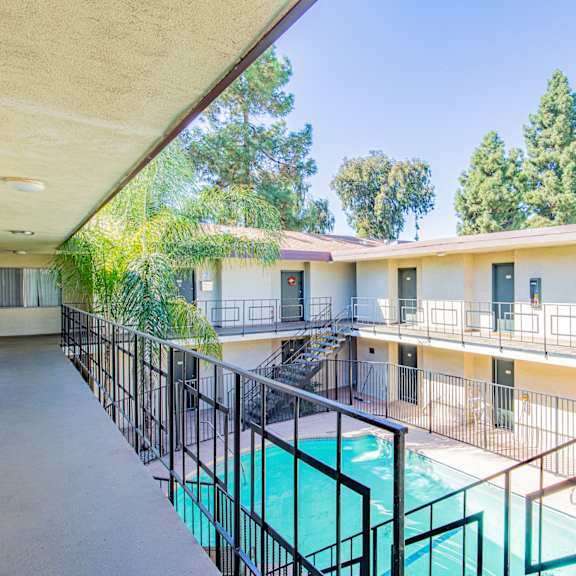 a balcony with a pool and a building with trees