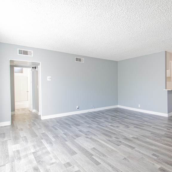 an empty living room with blue walls and a wood floor