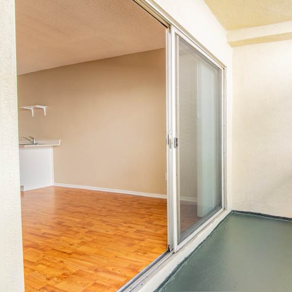 an empty room with a sliding glass door to a bathroom