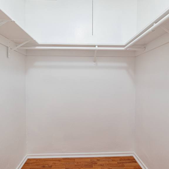 an empty room with white walls and a wood floor