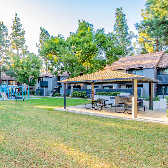 a park with picnic tables and buildings with trees at metro 3610, california