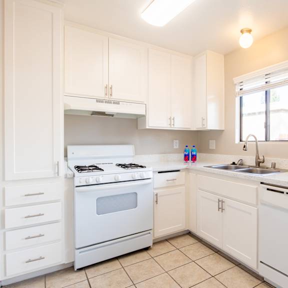 a kitchen with white appliances and white cabinets
