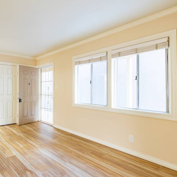 an empty room with white doors and windows and a wood floor