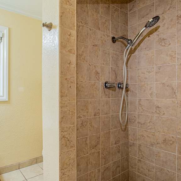 a bathroom with a shower and a sink and a window
