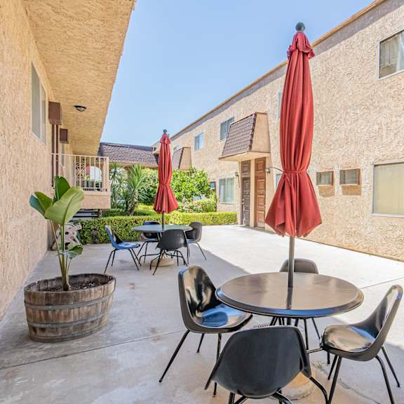 a patio with tables and chairs outside of a building