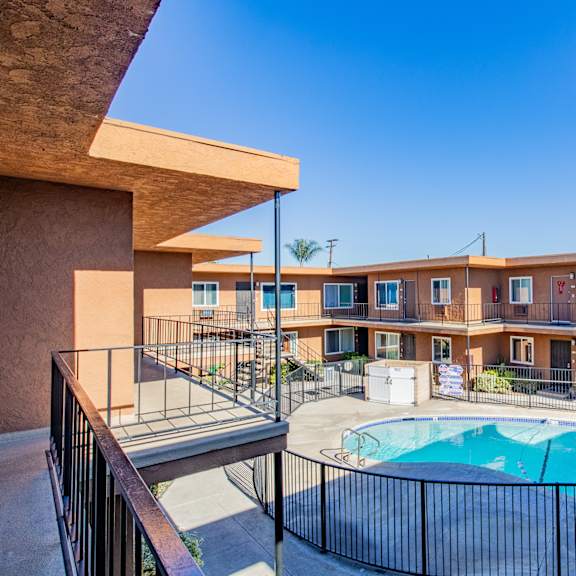 a pool in a courtyard surrounded by a black fence.