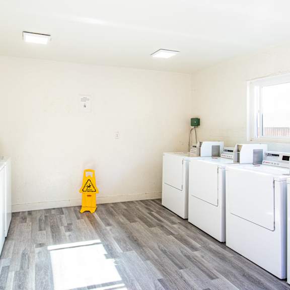 a room filled with washers and dryers and a yellow fire hydrant