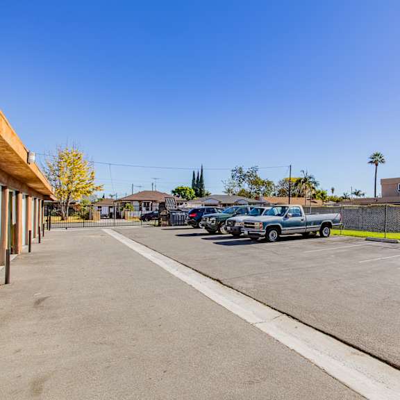 a parking lot with cars and a building in the background.