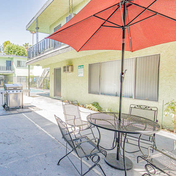 a patio with a table and chairs and an umbrella